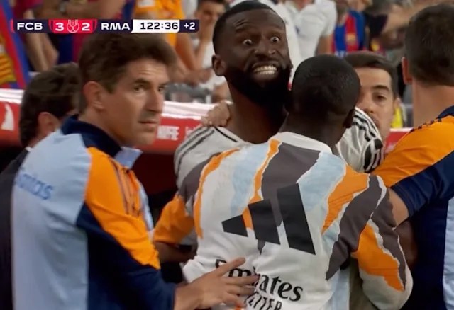 Antonio Rüdiger shouts and threaten ref whilst being held back by several men.